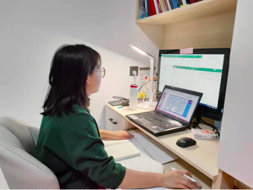 桌子上放着笔记本电脑的人描述已自动生成